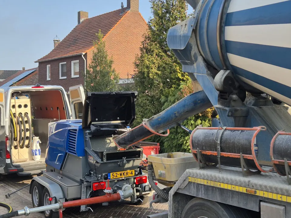 Betonpomp van Dohmen naast een betonmixer bij een woning