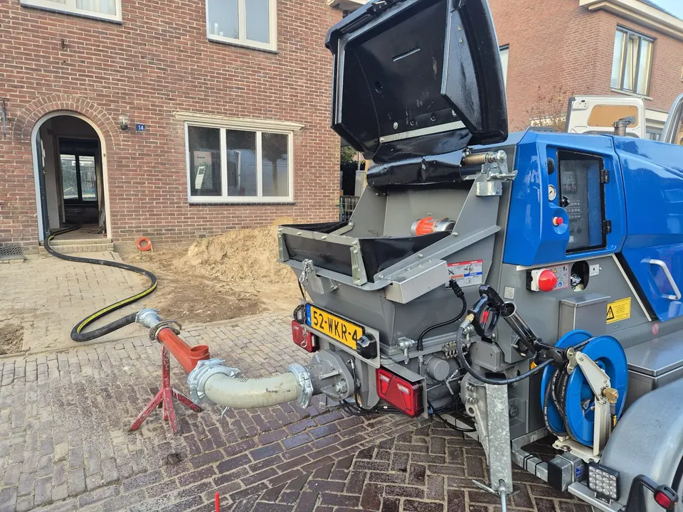 Betonpomp van Dohmen met slang bij een woning in aanbouw